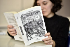 Luiza Urban e o livro de contos "Mosaicos" com ilustrações de sua autoria.