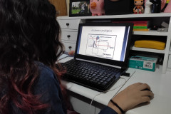 A estudante do curso de Fotografia do CJAP, Laura Pacheco, estuda o conteúdo enviado em seu computador.