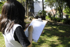Aluna do CJAP desenha em atividade ao ar livre no Museu Paranaense.