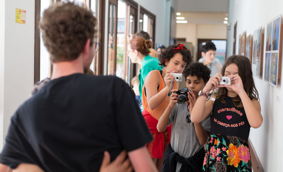 Fotografia Alunos do curso de fotografia cobrindo a abertura de uma exposição no Centro Juvenil de Artes.